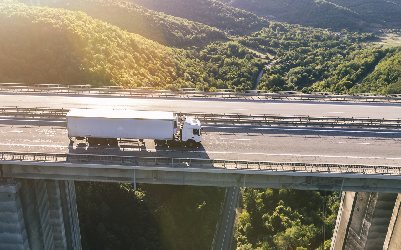 Trucks on highway in mountain at sunset